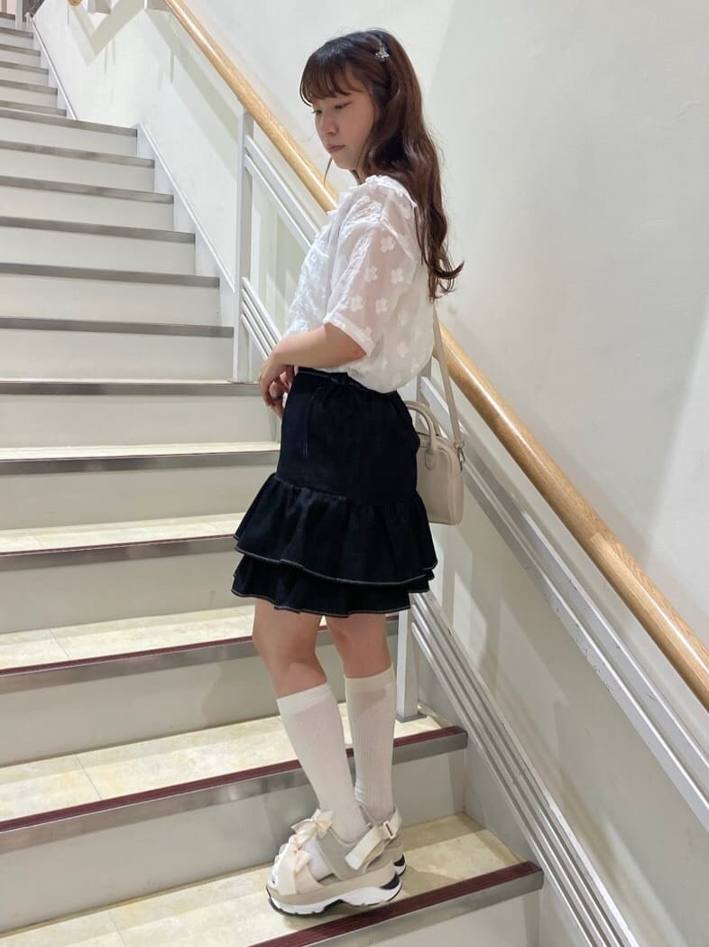 ブラック系のスカート、ホワイト系のサンダル、ホワイト系のショルダーバッグを着用したレディースの春コーディネートの3枚目の写真