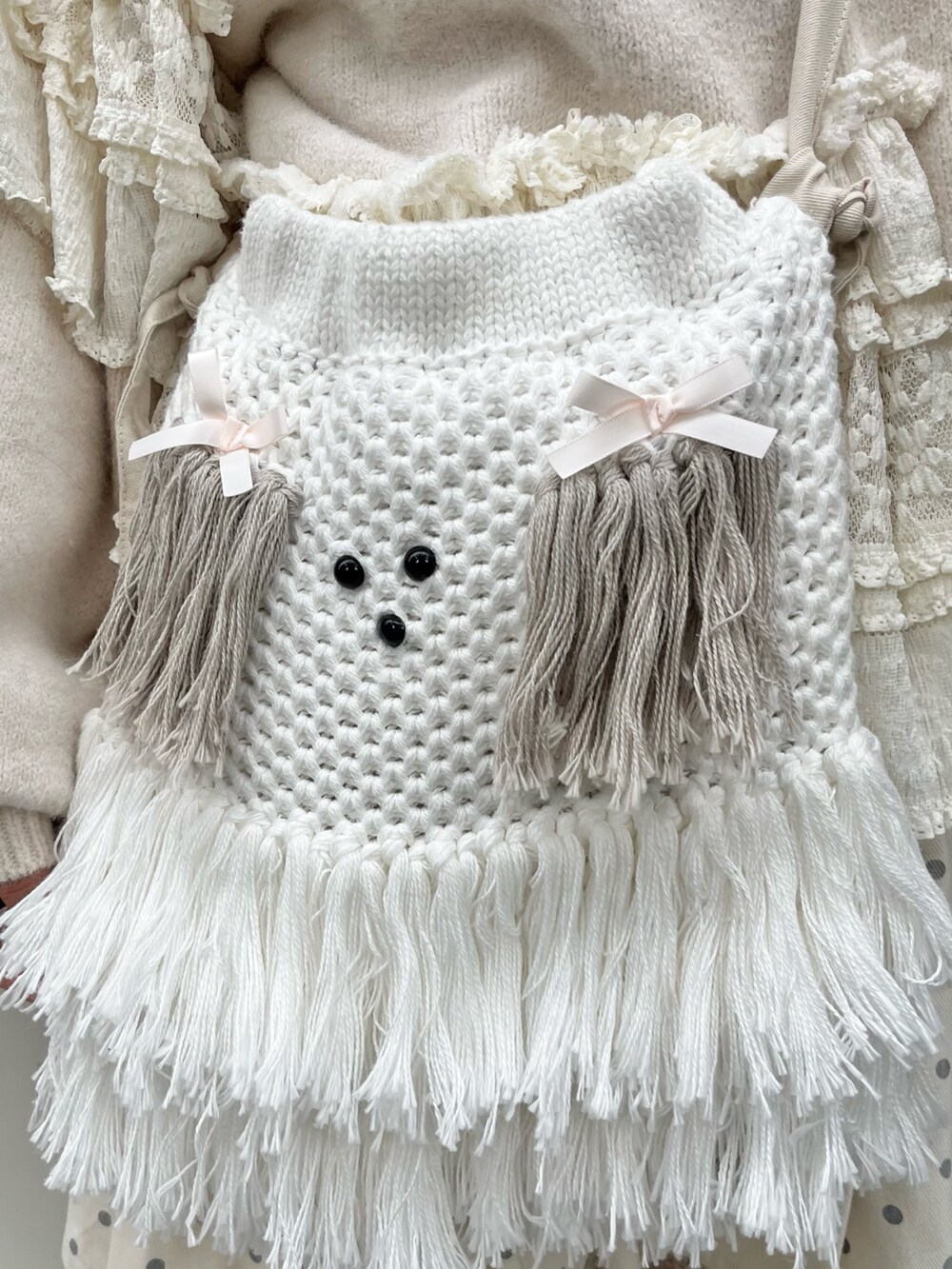 ホワイト系のニット/セーター、ホワイト系のスカート、ベージュ系のショルダーバッグを着用したレディースの秋コーディネートの7枚目の写真