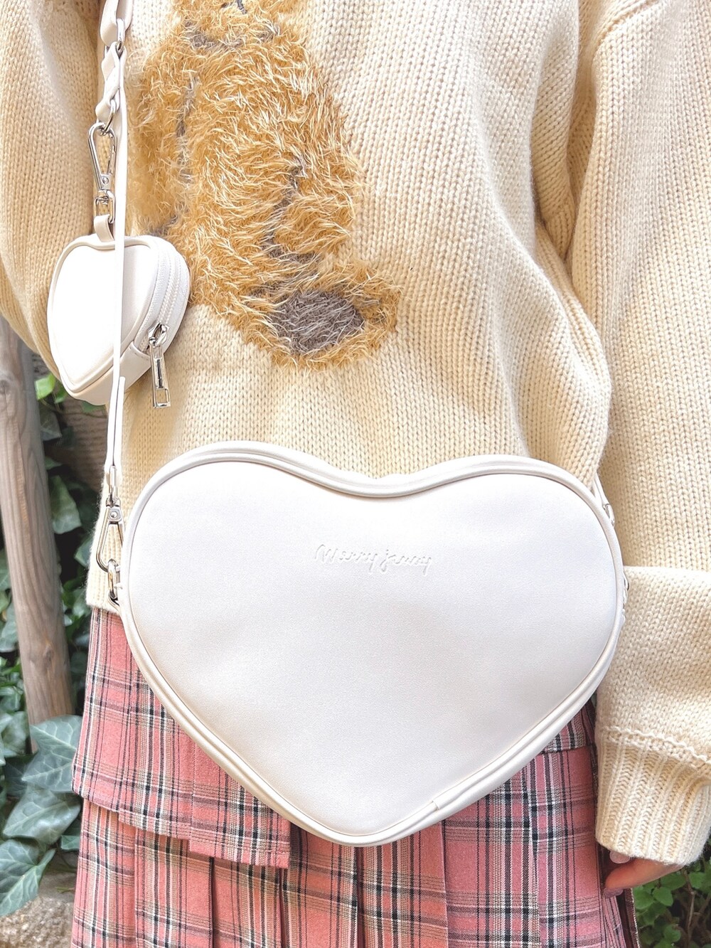 ホワイト系のニット/セーター、ホワイト系のショルダーバッグ、ピンク系のスカートを着用したレディースの秋コーディネートの7枚目の写真