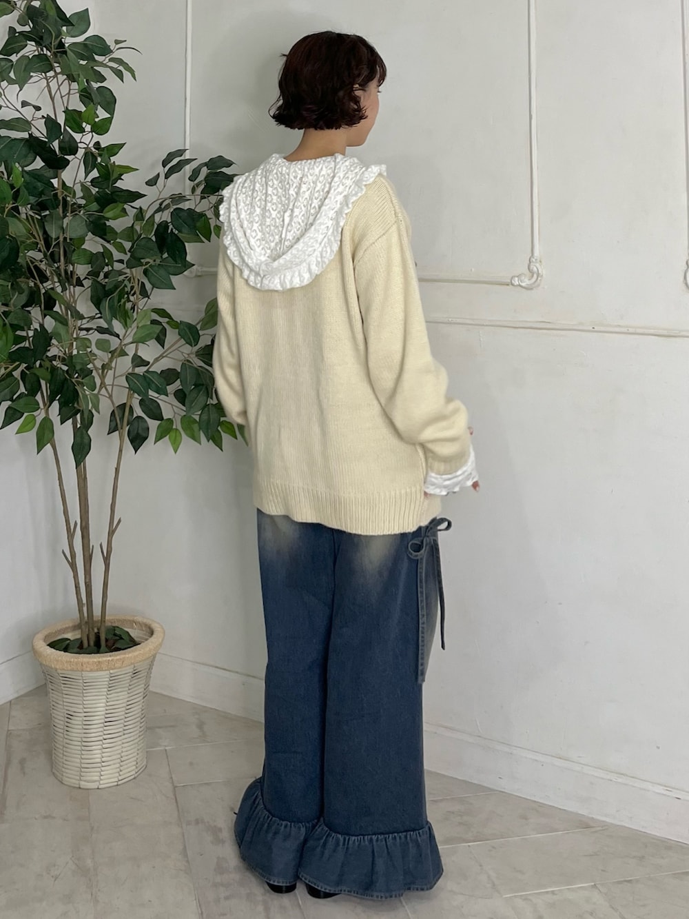 ホワイト系のTシャツ/カットソー、ホワイト系のニット/セーター、ブルー系のデニムパンツを着用したレディースの秋コーディネートの2枚目の写真