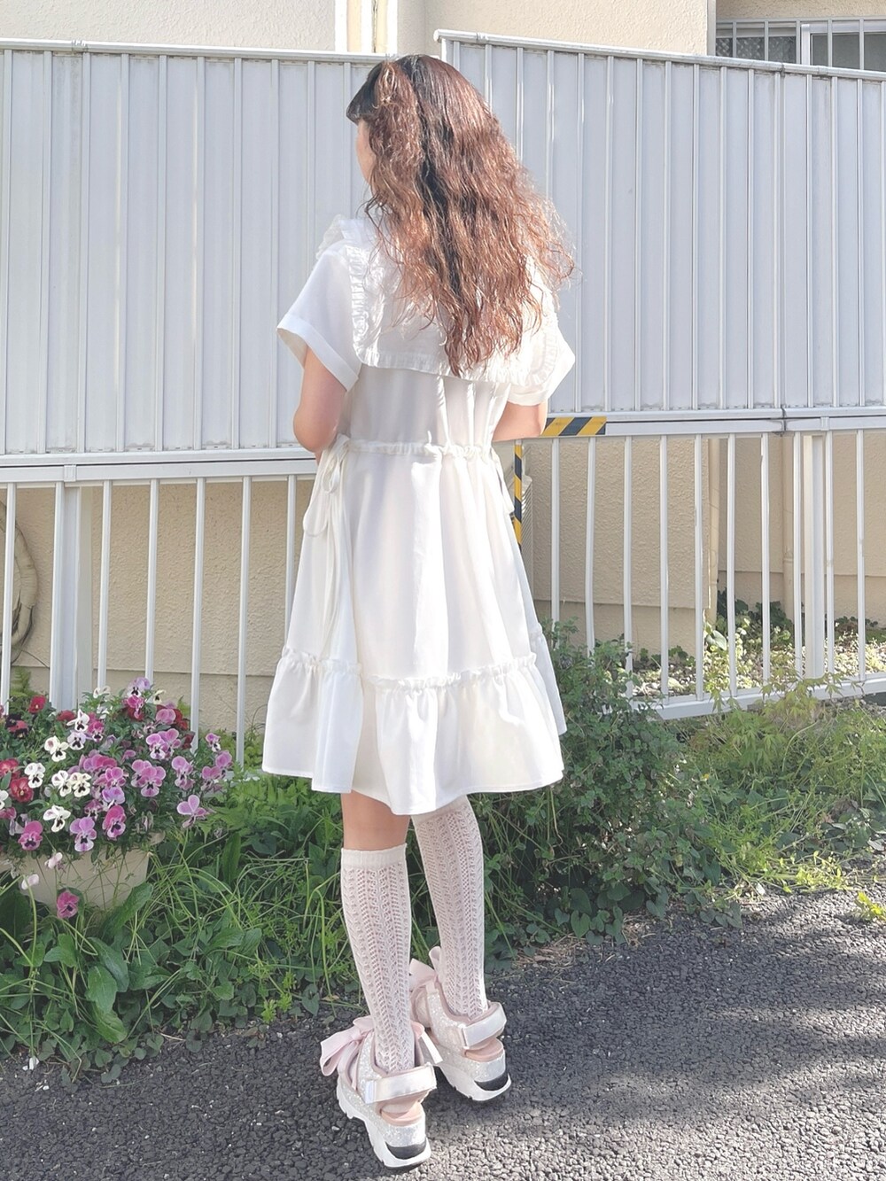 ホワイト系のワンピース、ピンク系のサンダルを着用したレディースの春コーディネートの3枚目の写真