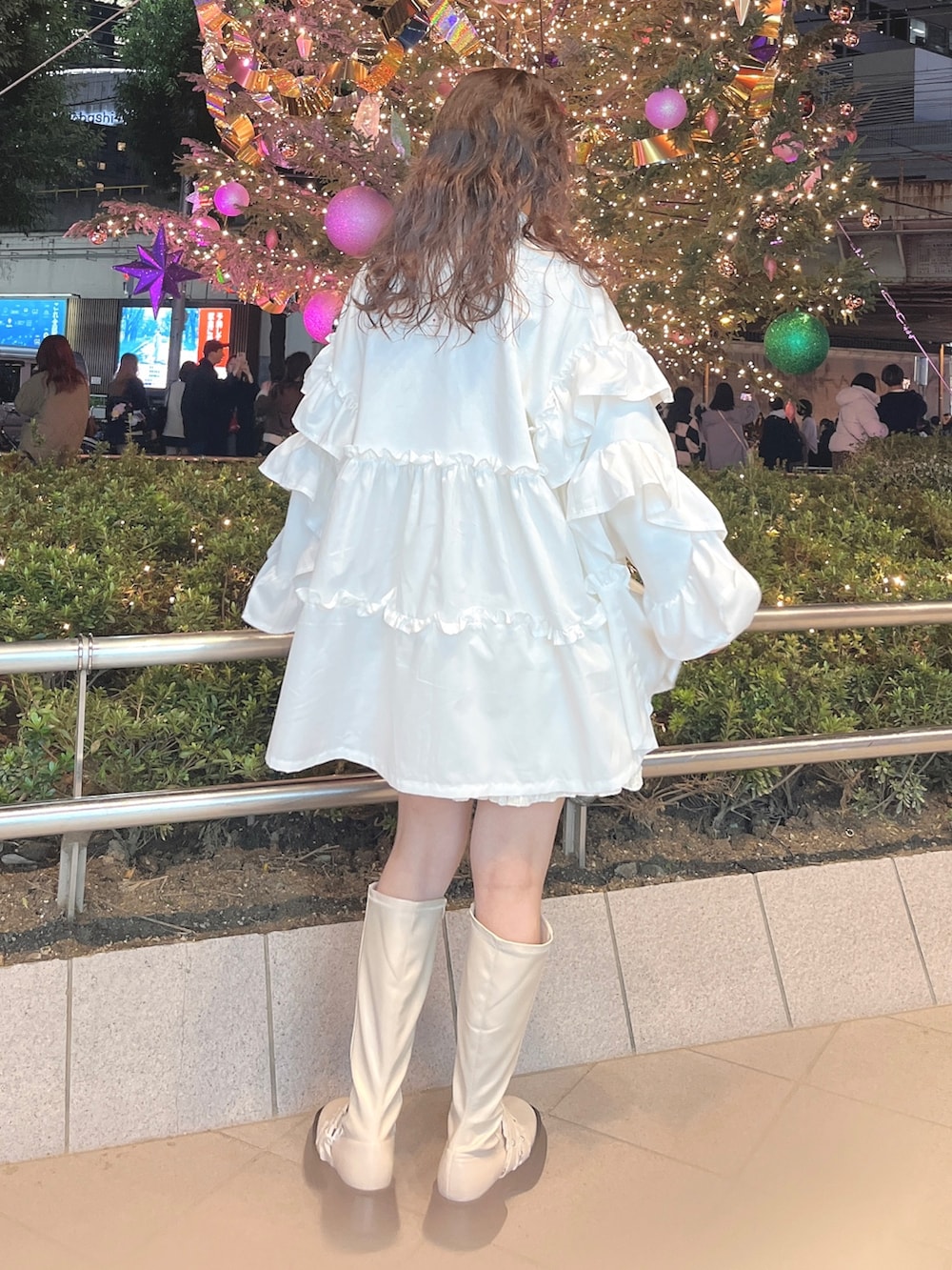 レッド系のチェスターコート、ホワイト系のニット/セーター、ホワイト系のスウェットを着用したレディースの冬コーディネートの8枚目の写真