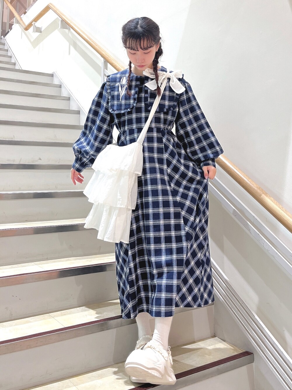 ブルー系のチェスターコート、ブルー系のワンピース、ホワイト系のショルダーバッグを着用したレディースの冬コーディネートの7枚目の写真