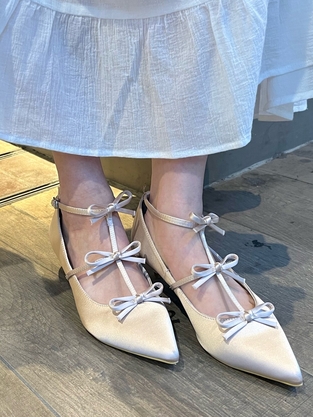 ブルー系のシャツ/ブラウス、ホワイト系のスカート、ブラウン系のパンプスを着用したレディースの春コーディネートの6枚目の写真