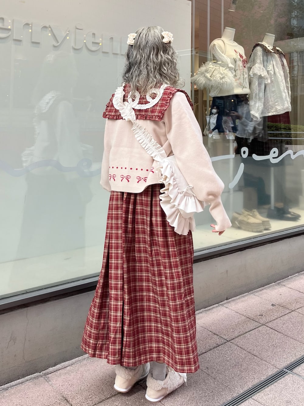 レッド系のワンピース、ホワイト系のカーディガン/ボレロ、ホワイト系のショルダーバッグを着用したレディースの秋コーディネートの3枚目の写真