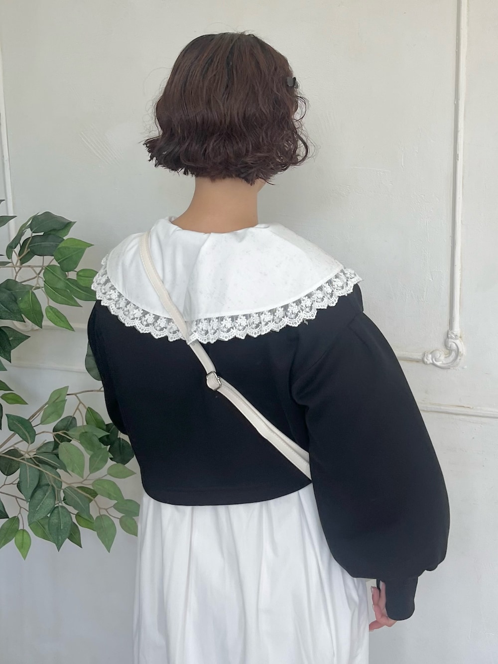 ホワイト系のワンピース、ブラック系のカーディガン/ボレロ、ホワイト系のショルダーバッグを着用したレディースの秋コーディネートの6枚目の写真