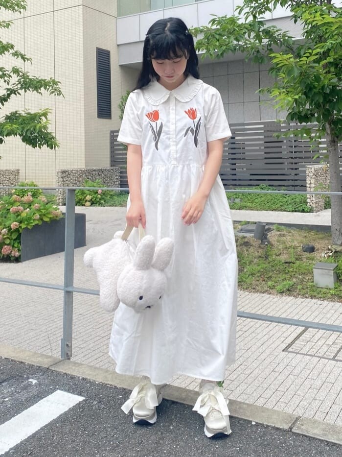 ホワイト系のハンドバッグ、ホワイト系のワンピースを着用したレディースの夏コーディネートの2枚目の写真