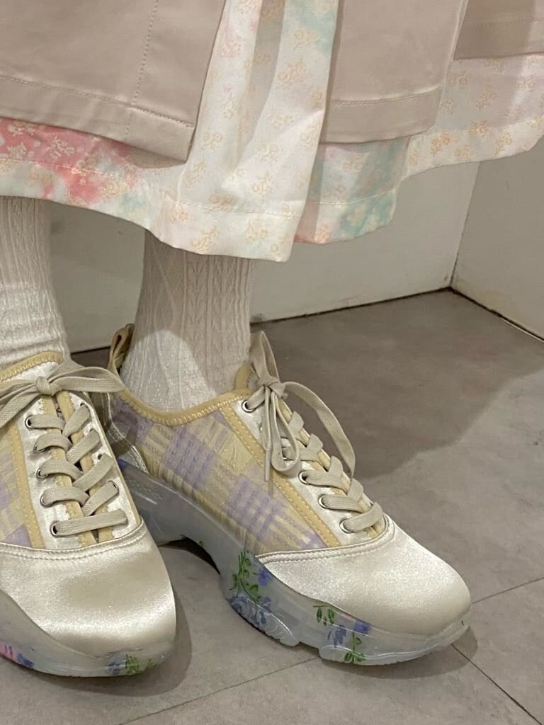 ホワイト系のトレンチコート、ピンク系のワンピース、ホワイト系のスニーカーを着用したレディースの冬コーディネートの7枚目の写真