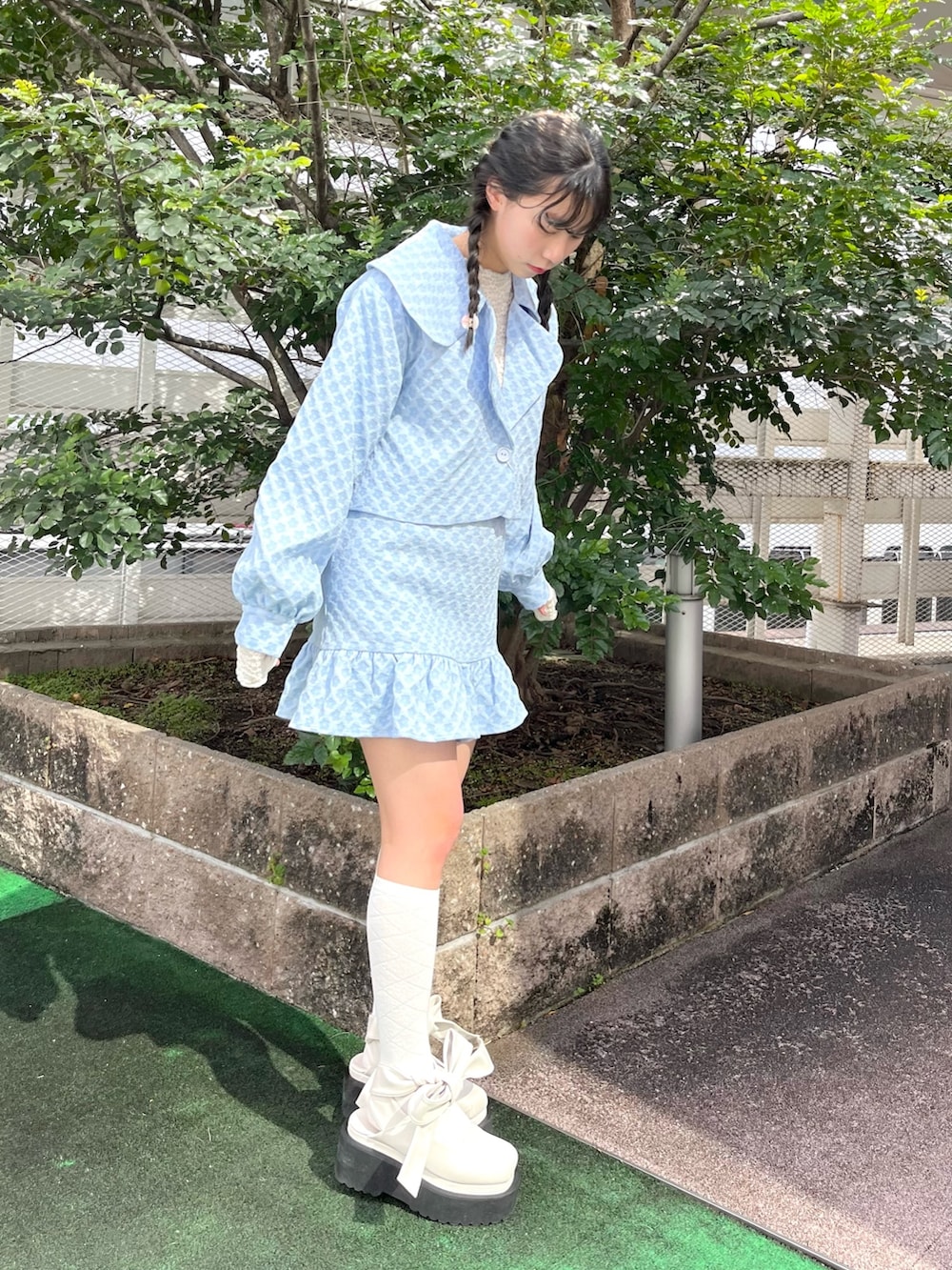 ブルー系のスカート、ホワイト系のパンプス、ブルー系のテーラードジャケットを着用したレディースの春コーディネートの3枚目の写真