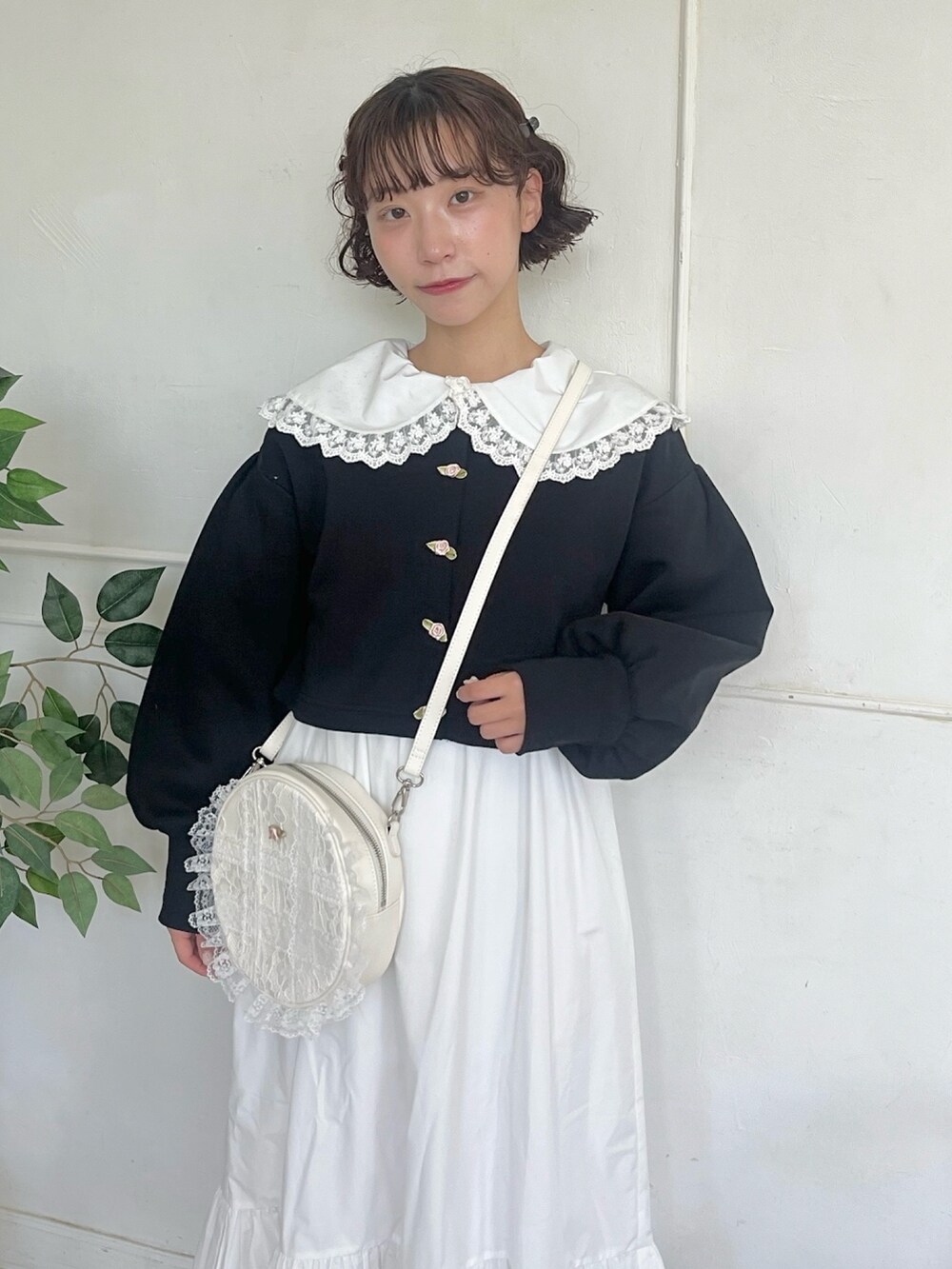 ホワイト系のワンピース、ブラック系のカーディガン/ボレロ、ホワイト系のショルダーバッグを着用したレディースの秋コーディネートの3枚目の写真