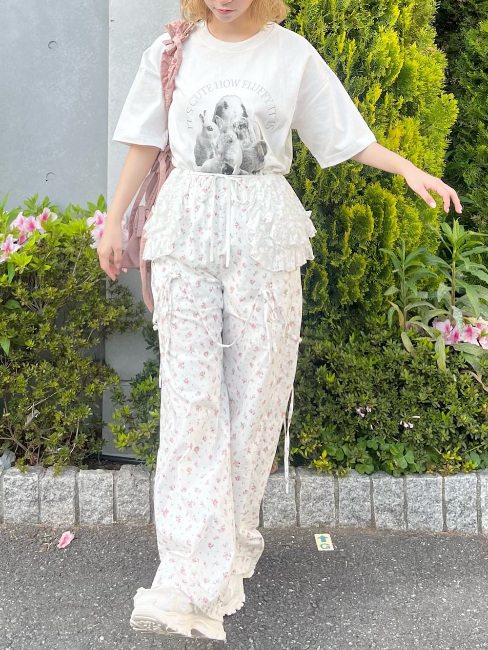 ホワイト系のTシャツ/カットソー、ホワイト系のスラックス、ピンク系のトートバッグを着用したレディースの春コーディネートの4枚目の写真