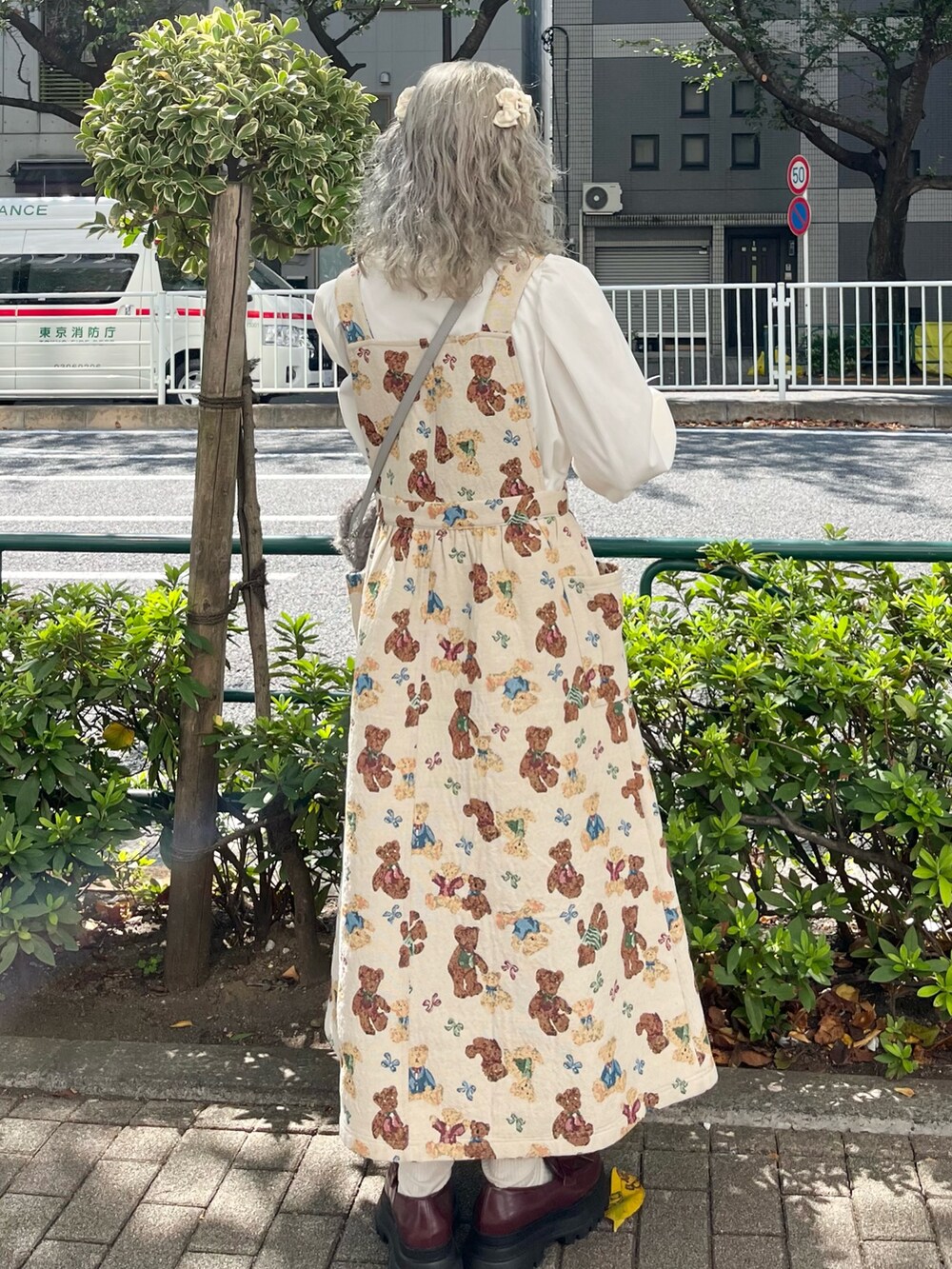 ホワイト系のシャツ/ブラウス、ホワイト系のジャンパースカート、グレー系のショルダーバッグを着用したレディースの秋コーディネートの2枚目の写真