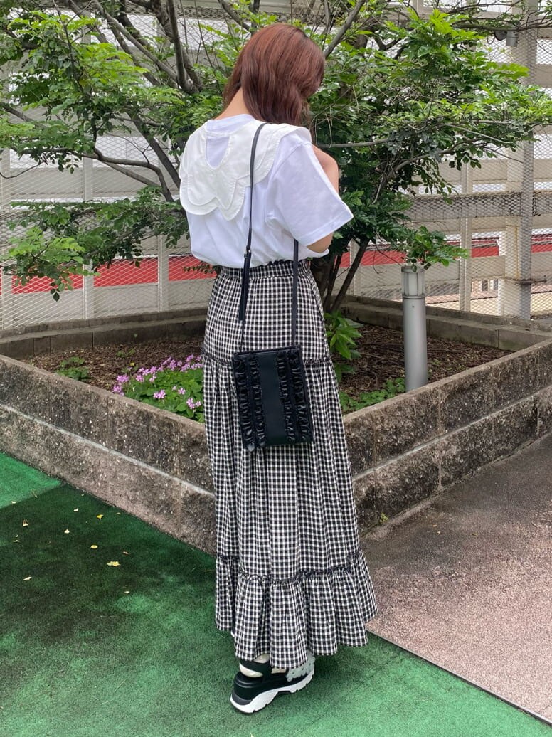 ブラック系のスカート、ブラック系のサンダル、ブラック系のショルダーバッグを着用したレディースの春コーディネートの3枚目の写真