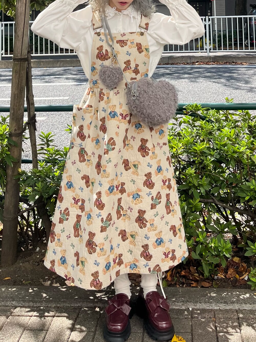 ホワイト系のシャツ/ブラウス、ホワイト系のジャンパースカート、グレー系のショルダーバッグを着用したレディースの秋コーディネートの3枚目の写真