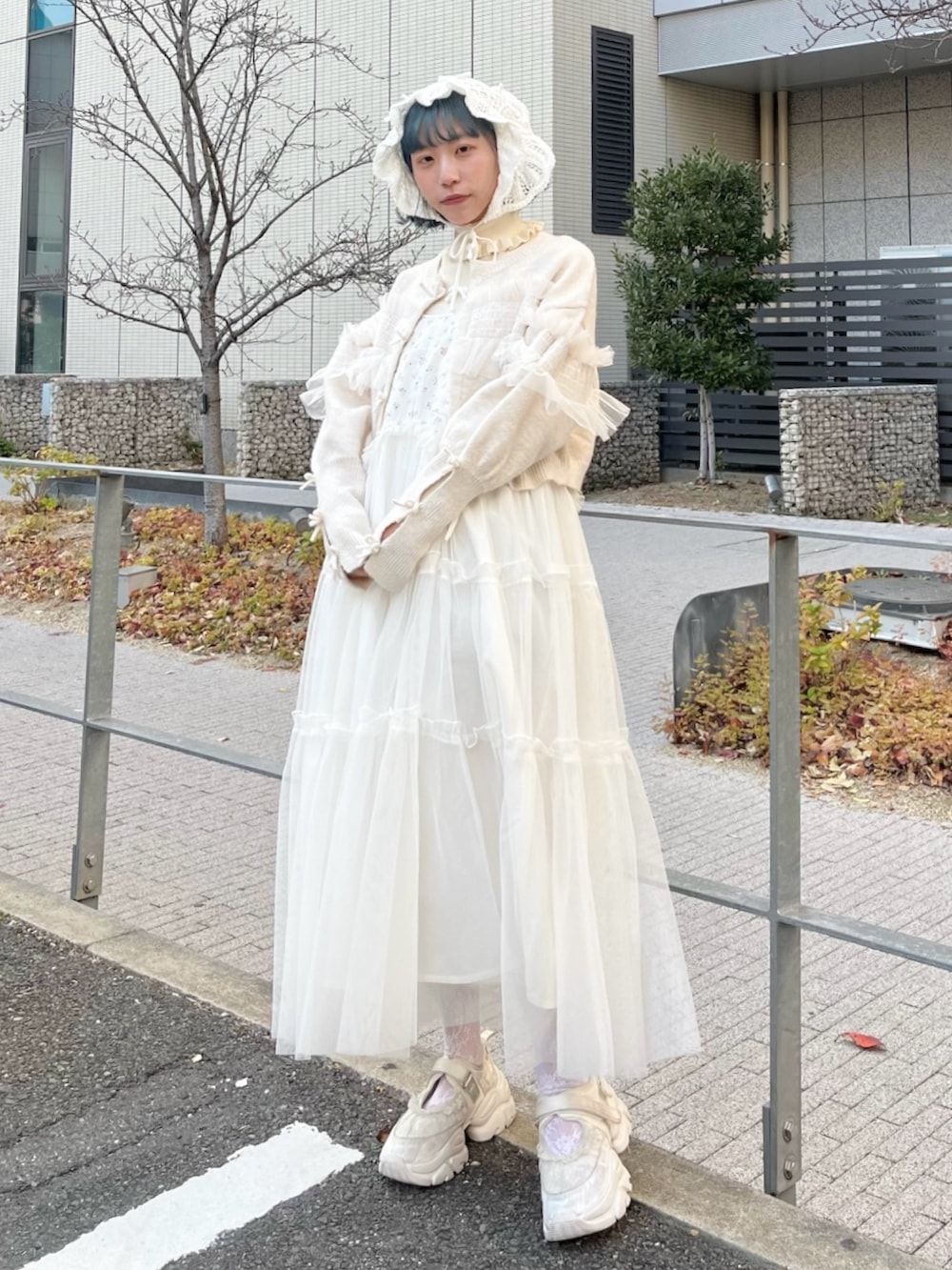 ホワイト系のニット/セーター、ホワイト系のカーディガン/ボレロ、ホワイト系のワンピースを着用したレディースの冬コーディネートの2枚目の写真
