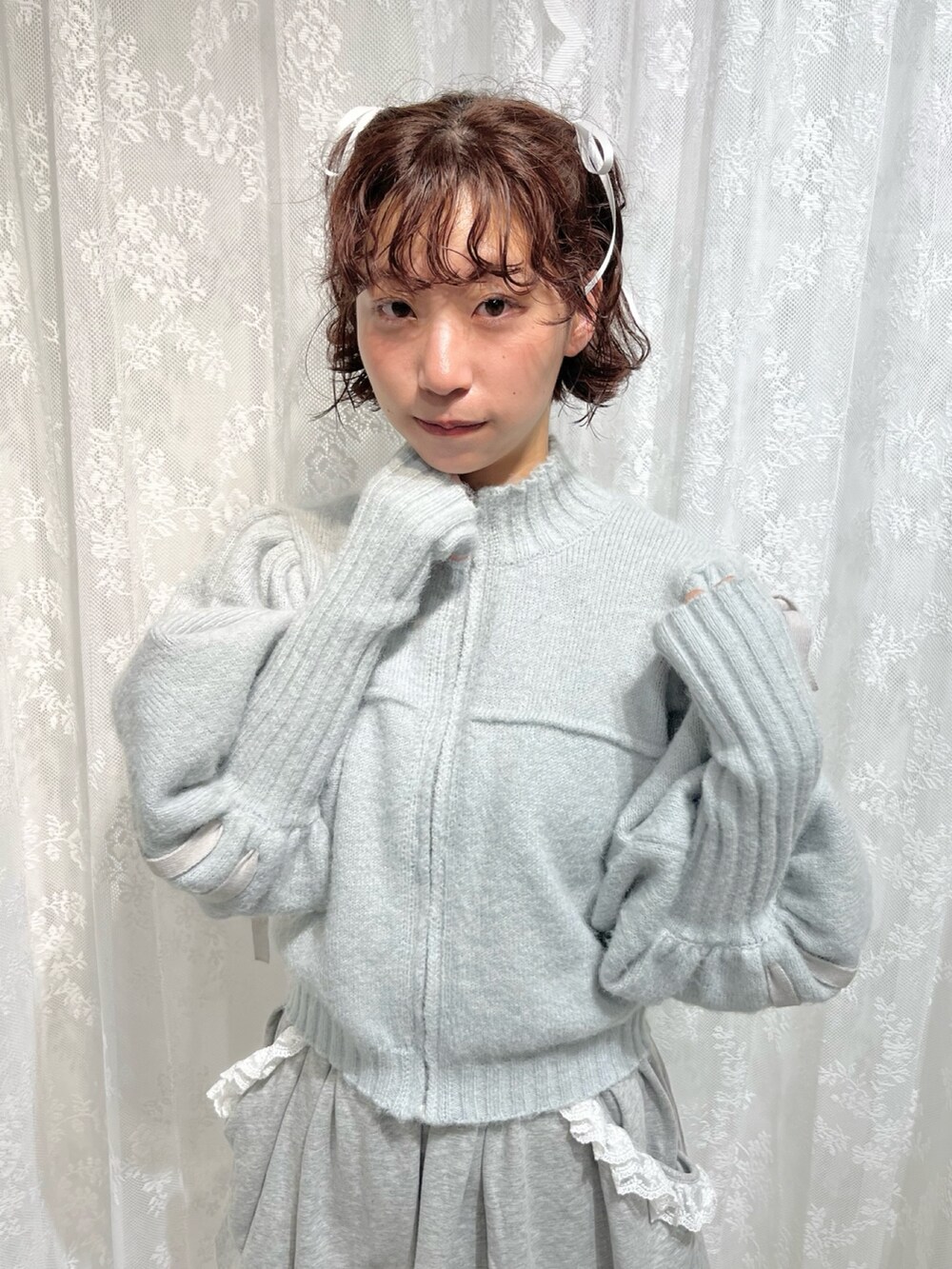 グリーン系のカーディガン/ボレロ、グレー系のスカート、ホワイト系のスニーカーを着用したレディースの秋コーディネートの3枚目の写真