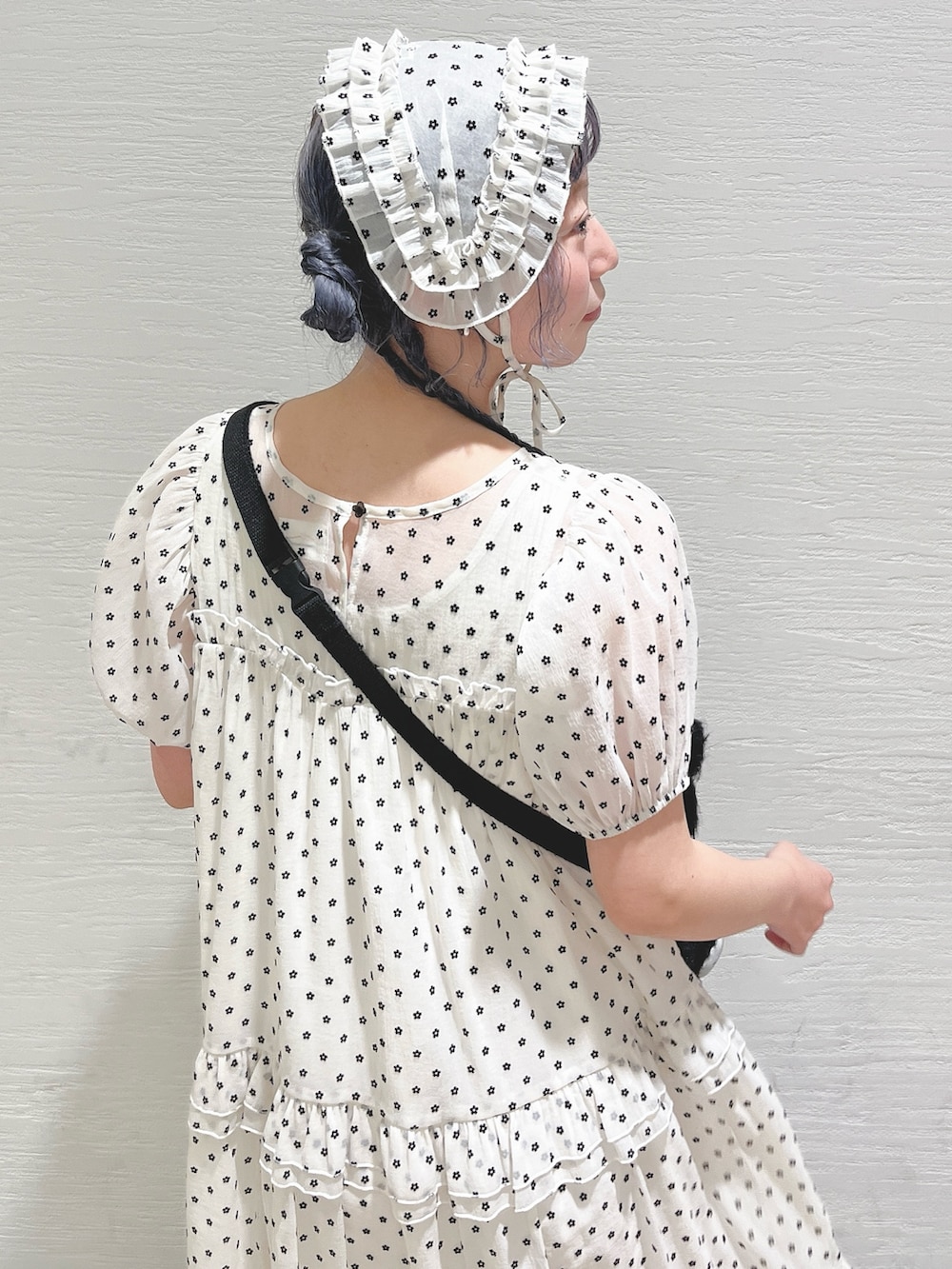 ホワイト系のワンピース、ブラック系のショルダーバッグ、ホワイト系のスニーカーを着用したレディースの春コーディネートの7枚目の写真