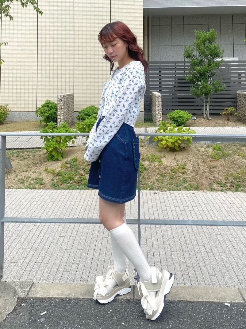 ホワイト系のサンダル、ブルー系のスカート、ホワイト系のアンサンブルを着用したレディースの秋コーディネートの2枚目の写真