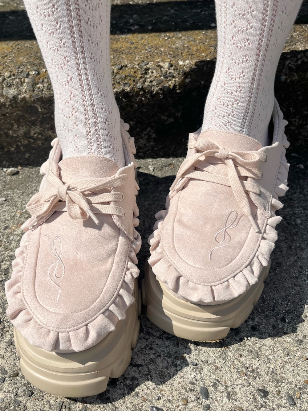 ピンク系のダッフルコート、ホワイト系のニット/セーター、ホワイト系のその他パンツを着用したレディースの秋コーディネートの10枚目の写真