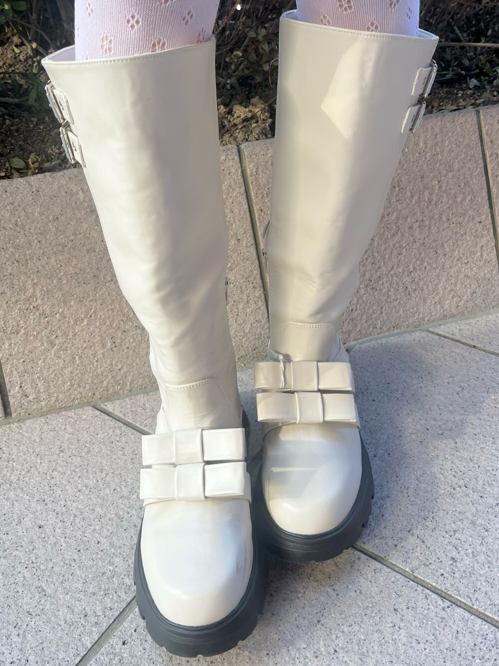 ホワイト系のカーディガン/ボレロ、ホワイト系のダウンジャケット/コート、ブラウン系のスカートを着用したレディースの冬コーディネートの10枚目の写真