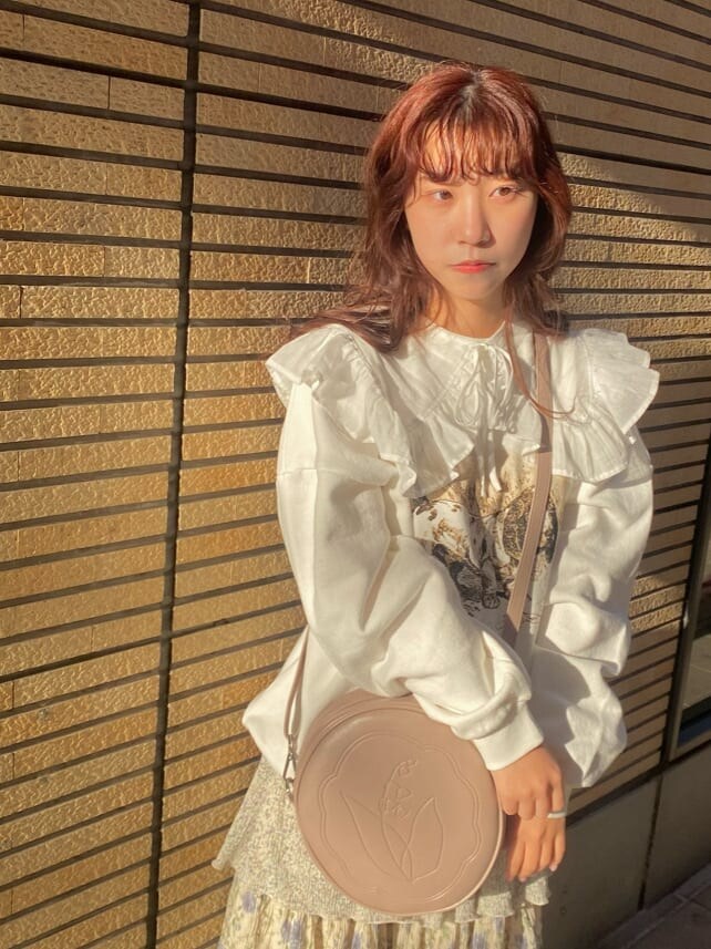 ホワイト系のスニーカー、ピンク系のショルダーバッグ、ホワイト系のTシャツ/カットソーを着用したレディースの冬コーディネートの6枚目の写真