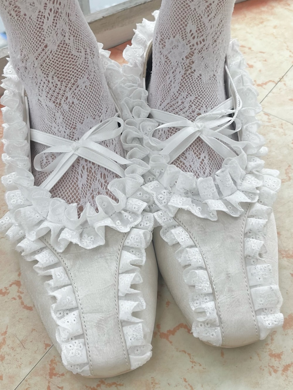 ホワイト系のTシャツ/カットソー、ホワイト系のショルダーバッグ、ピンク系のスカートを着用したレディースの冬コーディネートの9枚目の写真