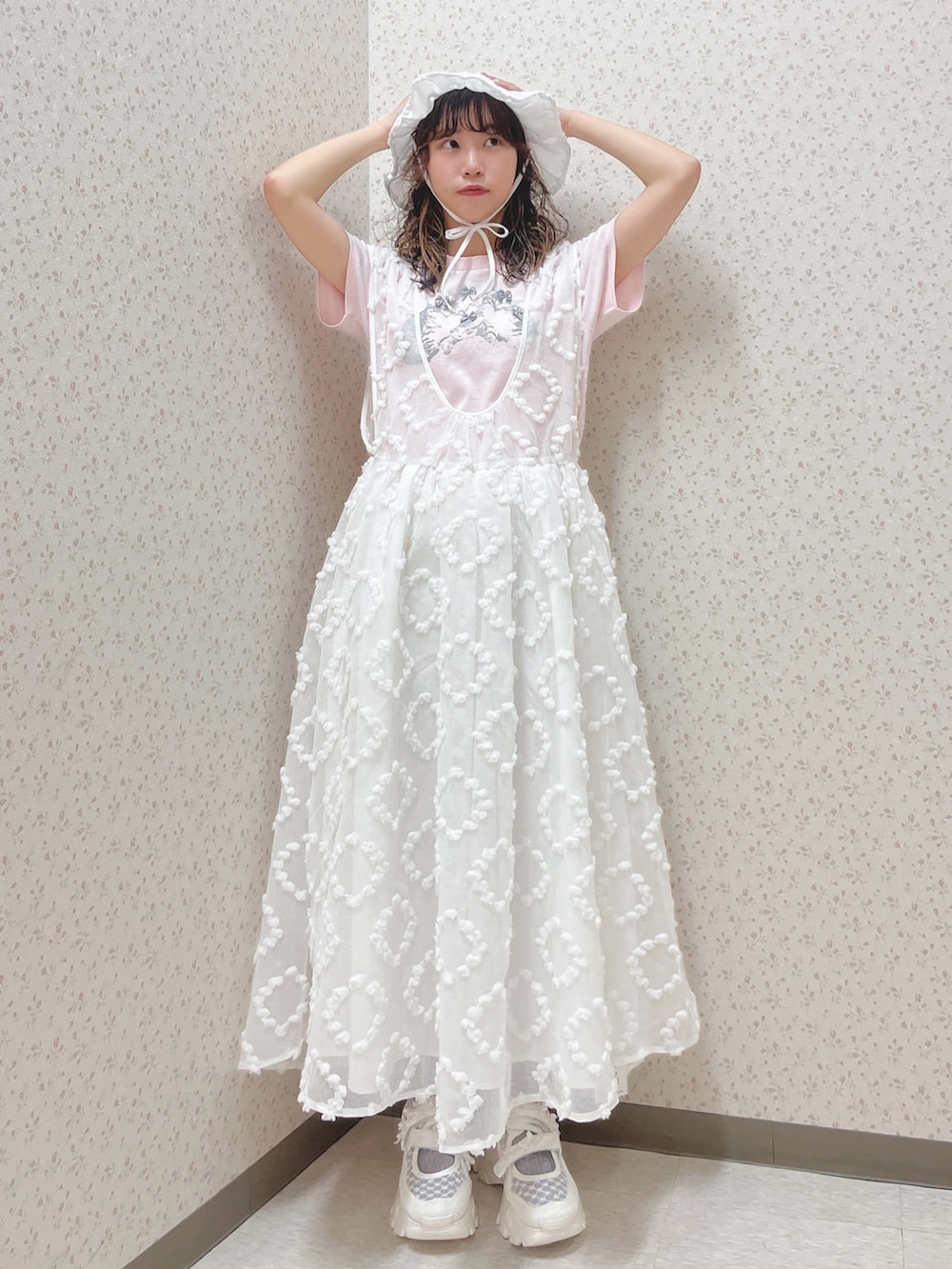 ピンク系のTシャツ/カットソー、ホワイト系のジャンパースカート、ホワイト系のスニーカーを着用したレディースの夏コーディネートの2枚目の写真