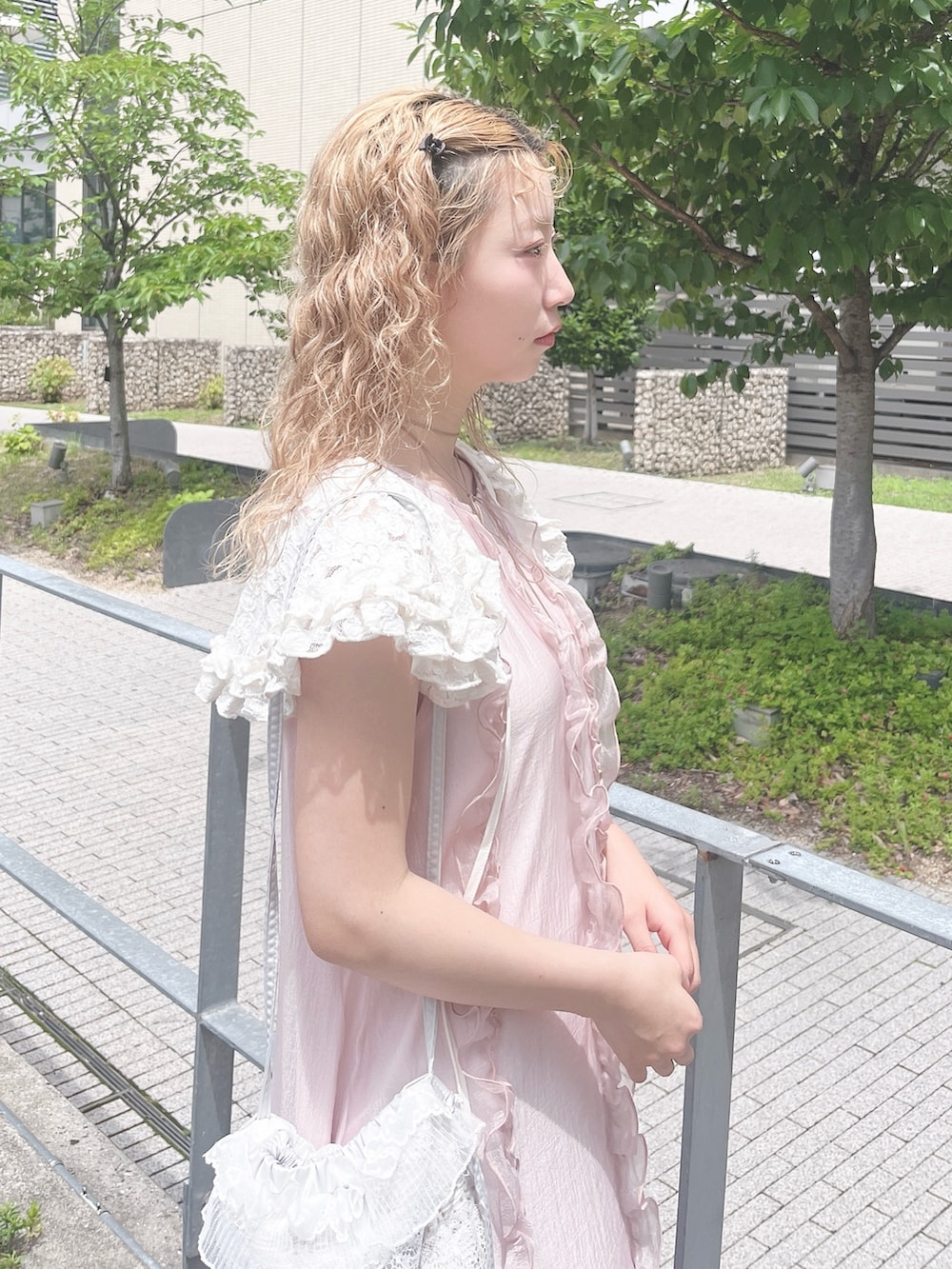 ピンク系のワンピース、ホワイト系のバレエシューズ、ブルー系のショルダーバッグを着用したレディースの夏コーディネートの6枚目の写真