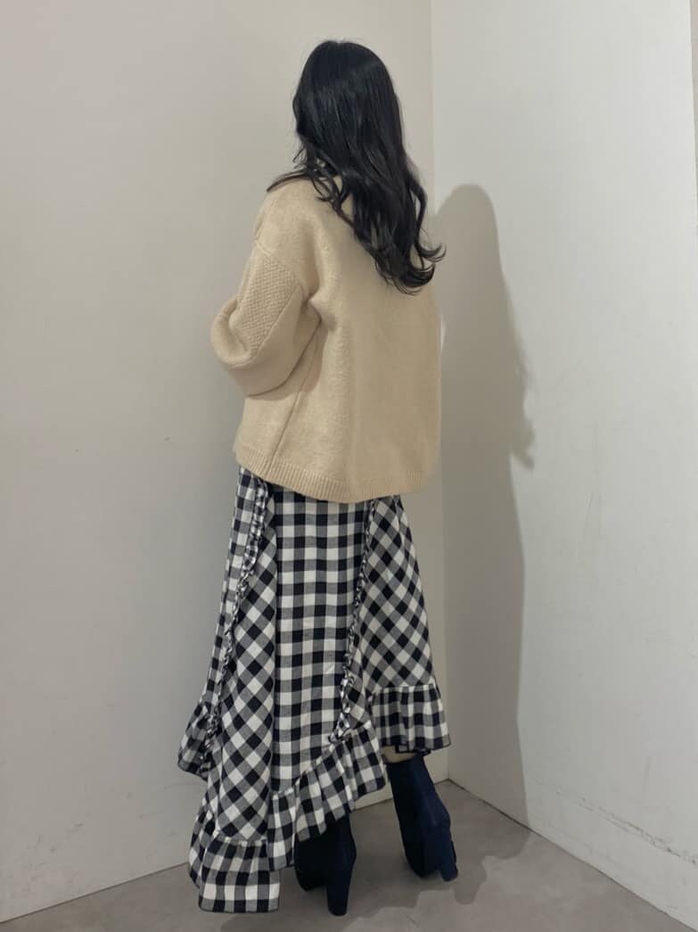 ブラック系のスカート、ブルー系のブーツ、ホワイト系のニット/セーターを着用したレディースの秋コーディネートの3枚目の写真