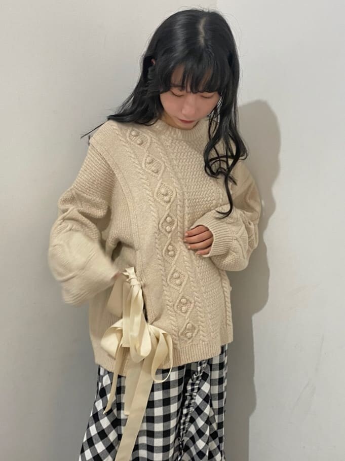 ブラック系のスカート、ブルー系のブーツ、ホワイト系のニット/セーターを着用したレディースの秋コーディネートの4枚目の写真