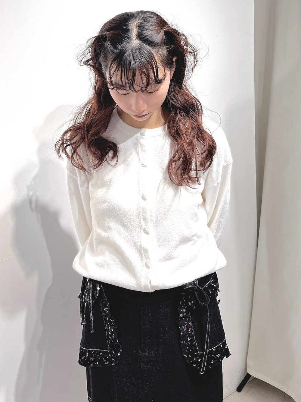 ホワイト系のカーディガン/ボレロ、ブラック系のデニムスカート、ブラック系のスニーカーを着用したレディースの冬コーディネートの7枚目の写真