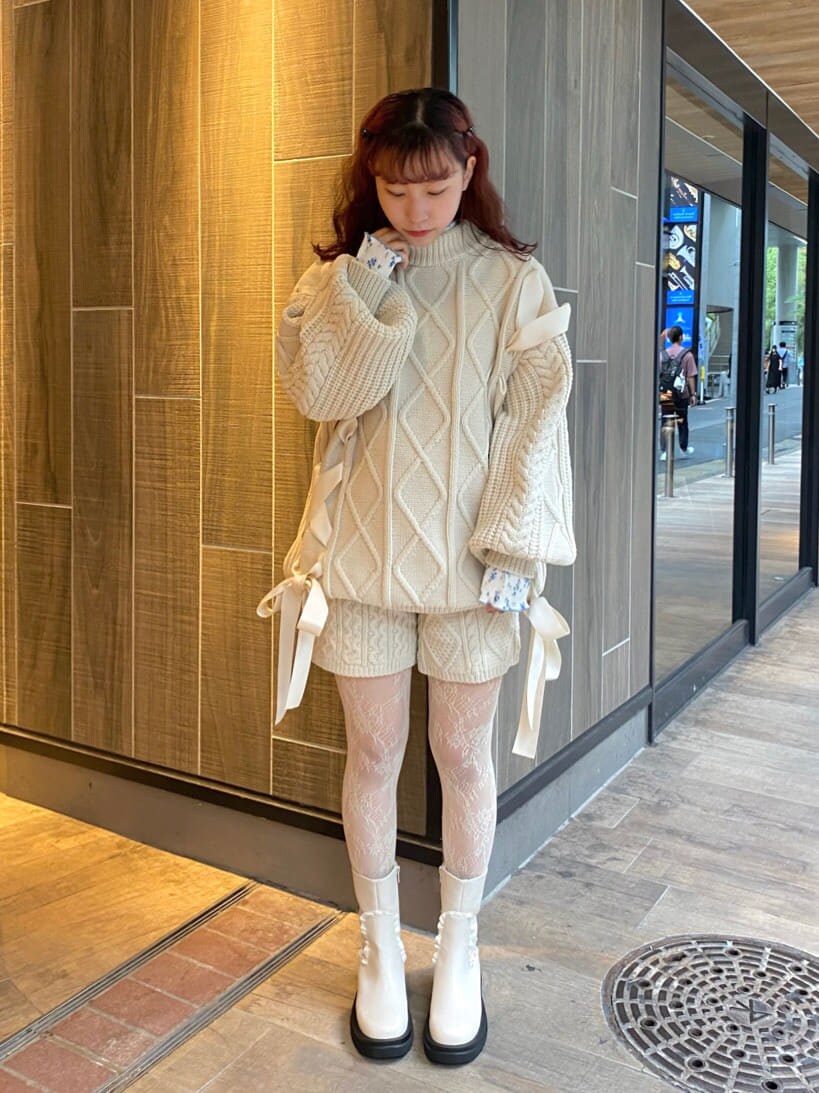 ホワイト系のニット/セーター、ホワイト系のブーツ、ブルー系のチュニックを着用したレディースの秋コーディネートの2枚目の写真