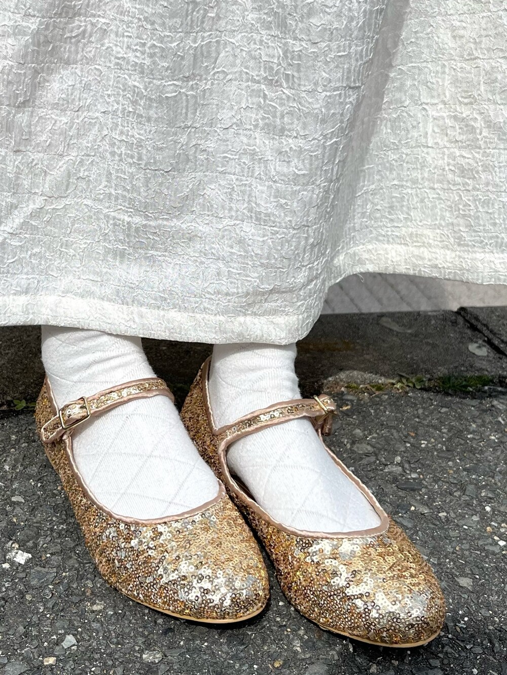 ホワイト系のカーディガン/ボレロ、ホワイト系のワンピース、ゴールド系のパンプスを着用したレディースの春コーディネートの6枚目の写真