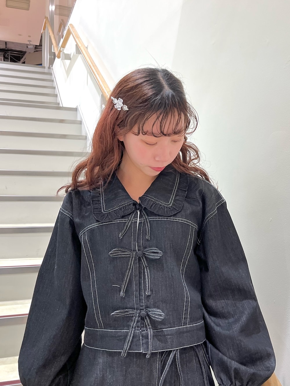 ブラック系のデニムジャケット、ブラック系のデニムスカート、ブラック系のスニーカーを着用したレディースの冬コーディネートの3枚目の写真