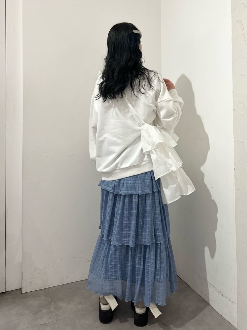 ホワイト系のトートバッグ、ホワイト系のスウェット、ブルー系のスカートを着用したレディースの春コーディネートの3枚目の写真