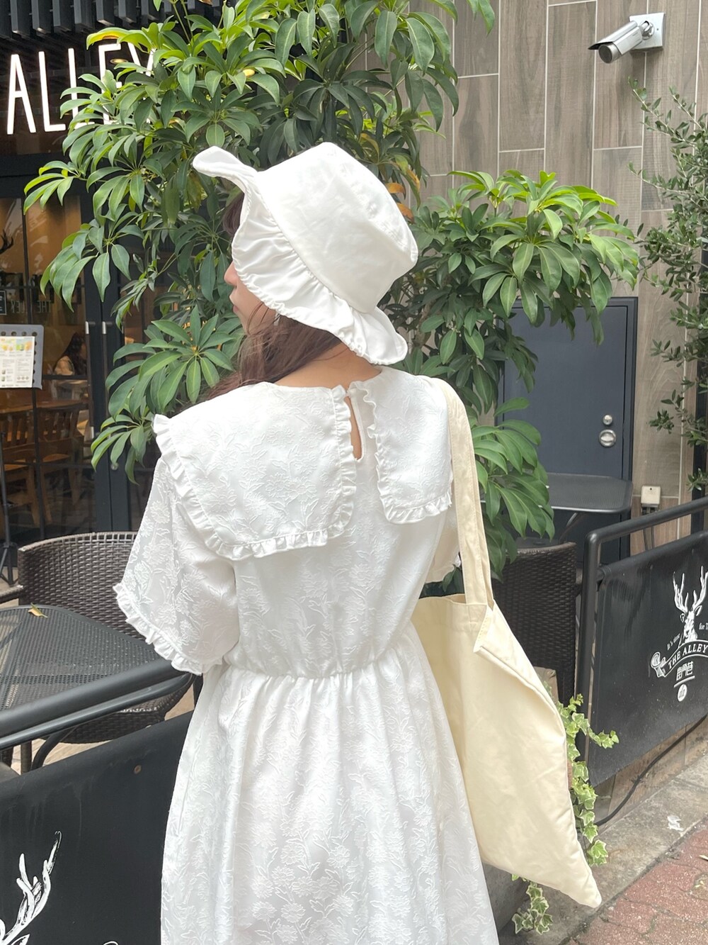 ホワイト系のスニーカー、ホワイト系のワンピース、ホワイト系のトートバッグを着用したレディースの夏コーディネートの5枚目の写真