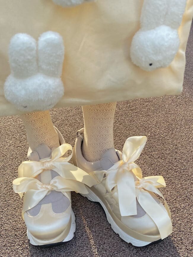 イエロー系のシャツ/ブラウス、ベージュ系のスカート、ホワイト系のスニーカーを着用したレディースの冬コーディネートの6枚目の写真