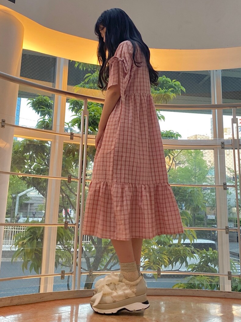 ピンク系のワンピースを着用したレディースの春コーディネートの3枚目の写真