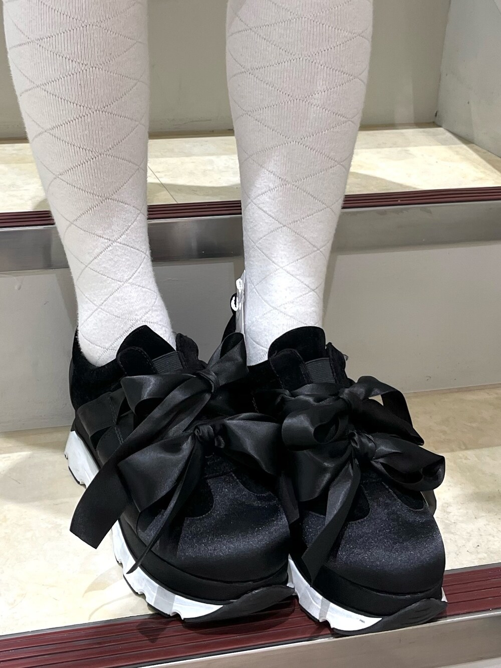 ブラック系のデニムジャケット、ブラック系のデニムスカート、ブラック系のスニーカーを着用したレディースの冬コーディネートの4枚目の写真