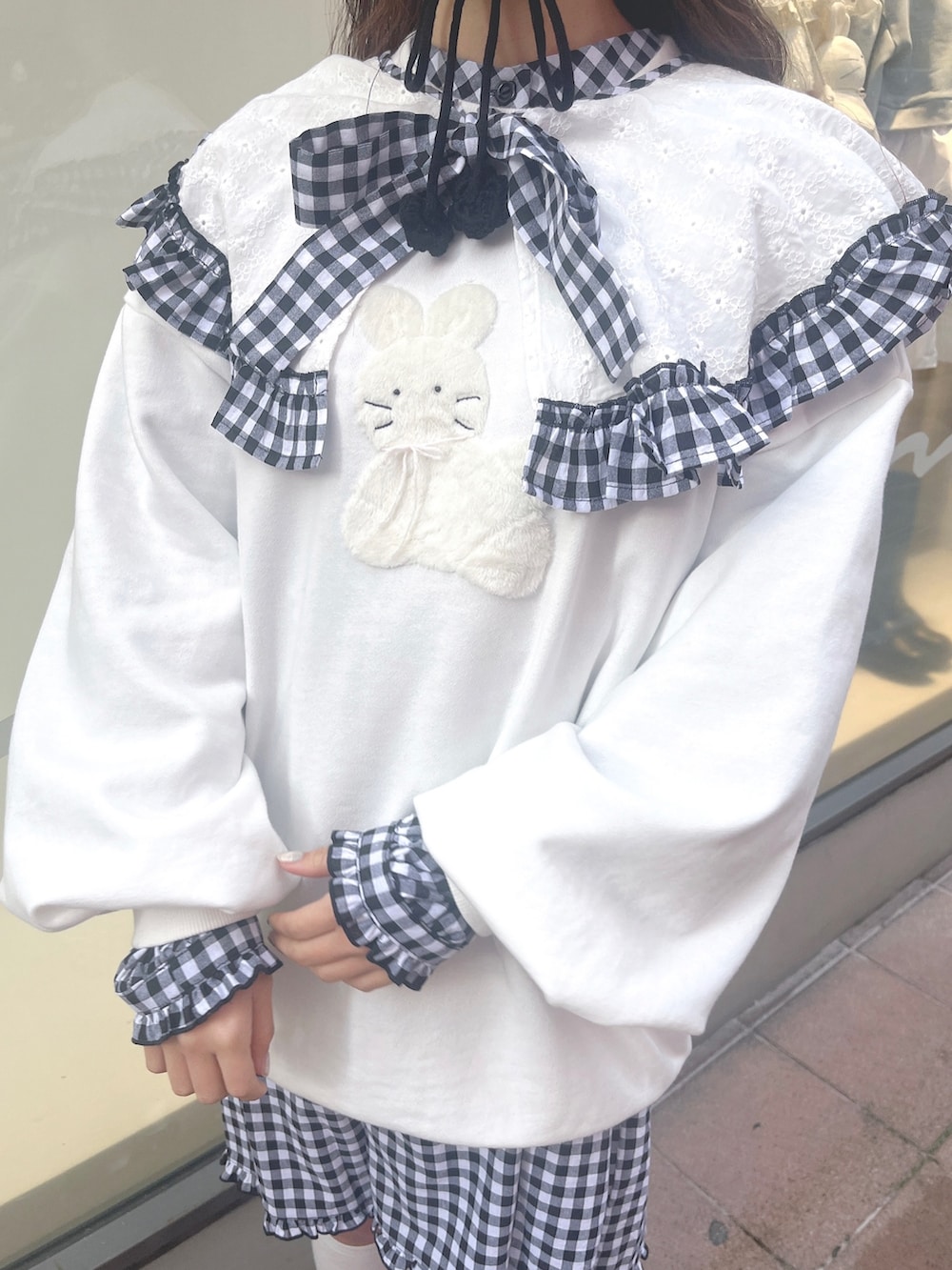 ホワイト系のスウェット、ブラック系のワンピース、ブラック系のスニーカーを着用したレディースの冬コーディネートの9枚目の写真