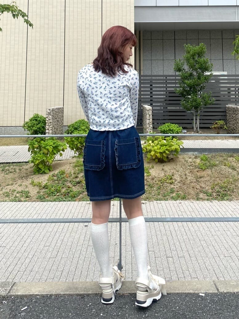 ホワイト系のサンダル、ブルー系のスカート、ホワイト系のアンサンブルを着用したレディースの秋コーディネートの3枚目の写真