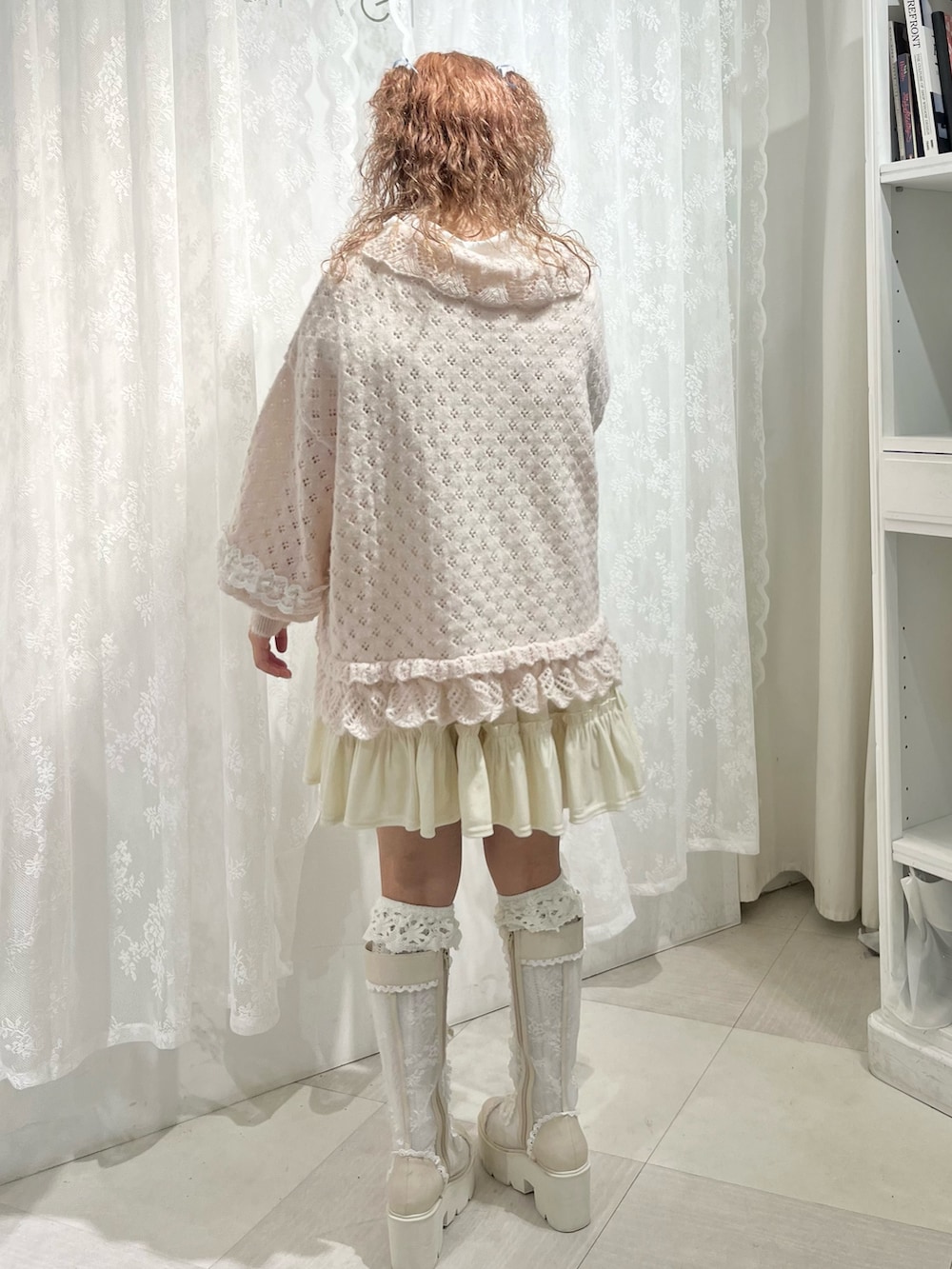 ピンク系のニット/セーター、ホワイト系のワンピース、ホワイト系のシャツ/ブラウスを着用したレディースの春コーディネートの3枚目の写真