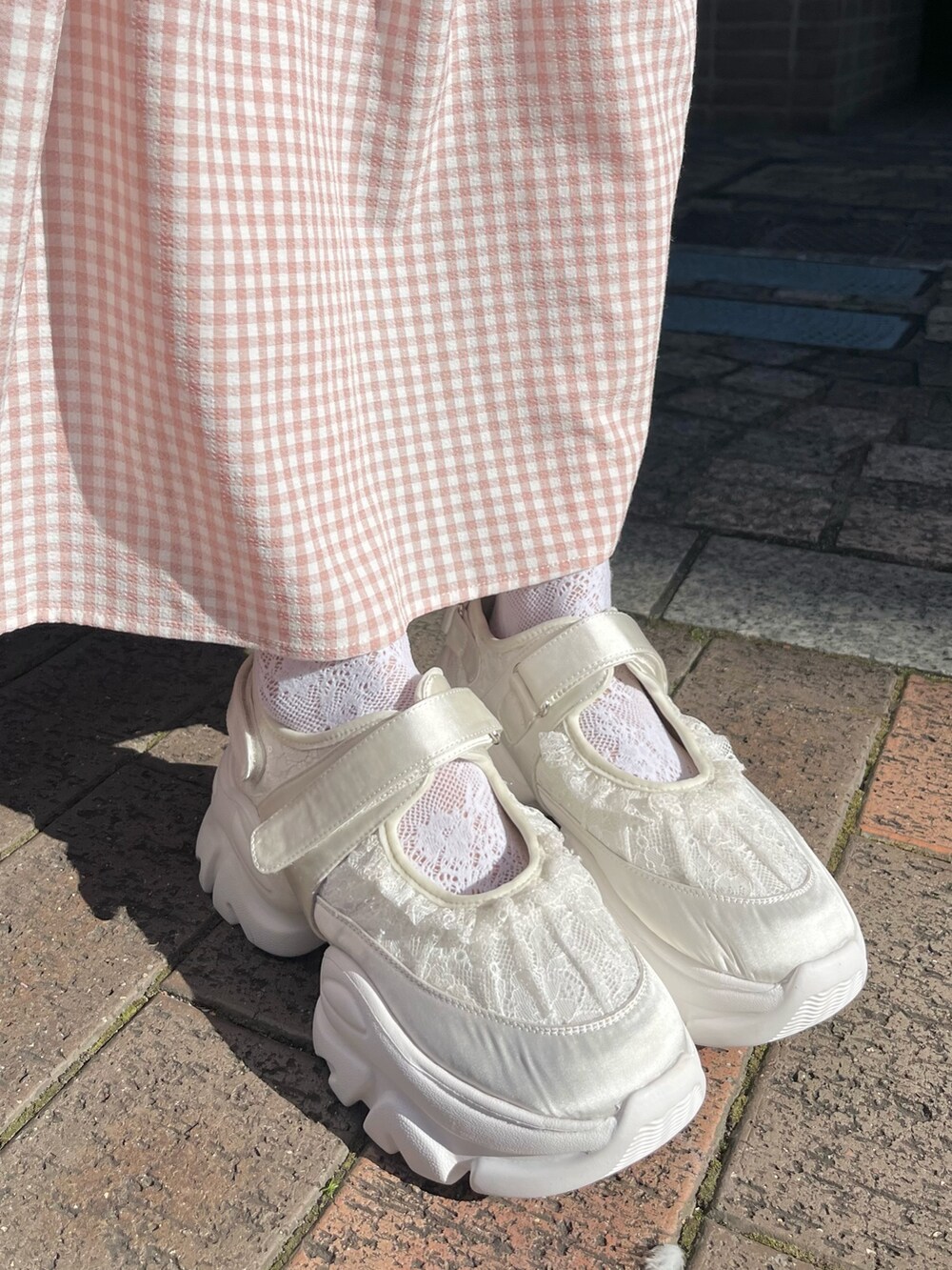 ピンク系のワンピース、ピンク系のジャージ、ホワイト系のスニーカーを着用したレディースの冬コーディネートの10枚目の写真