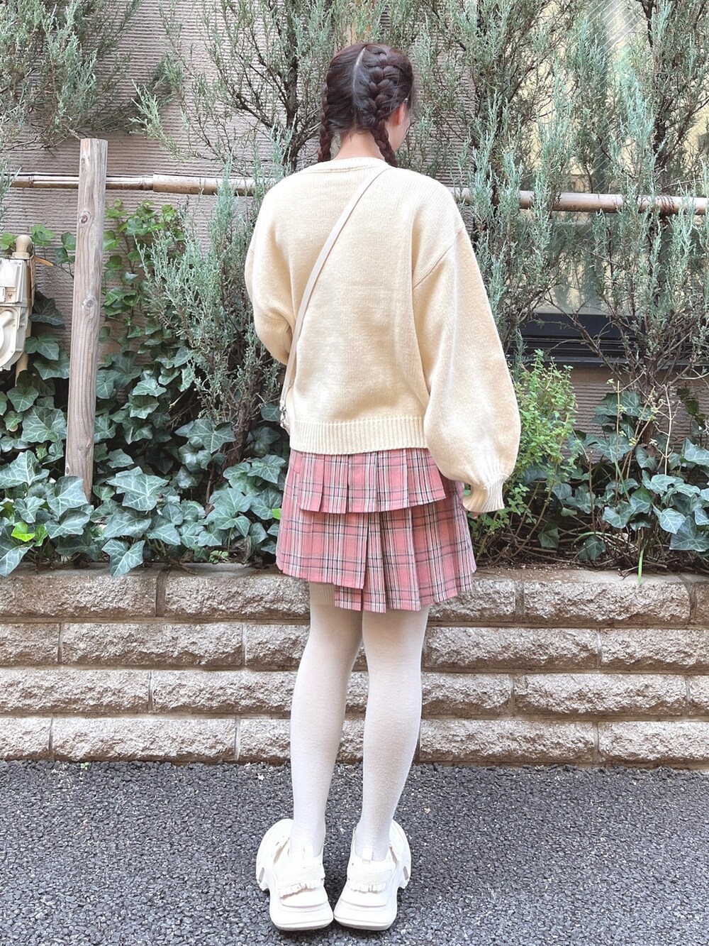 ホワイト系のニット/セーター、ホワイト系のショルダーバッグ、ピンク系のスカートを着用したレディースの秋コーディネートの4枚目の写真