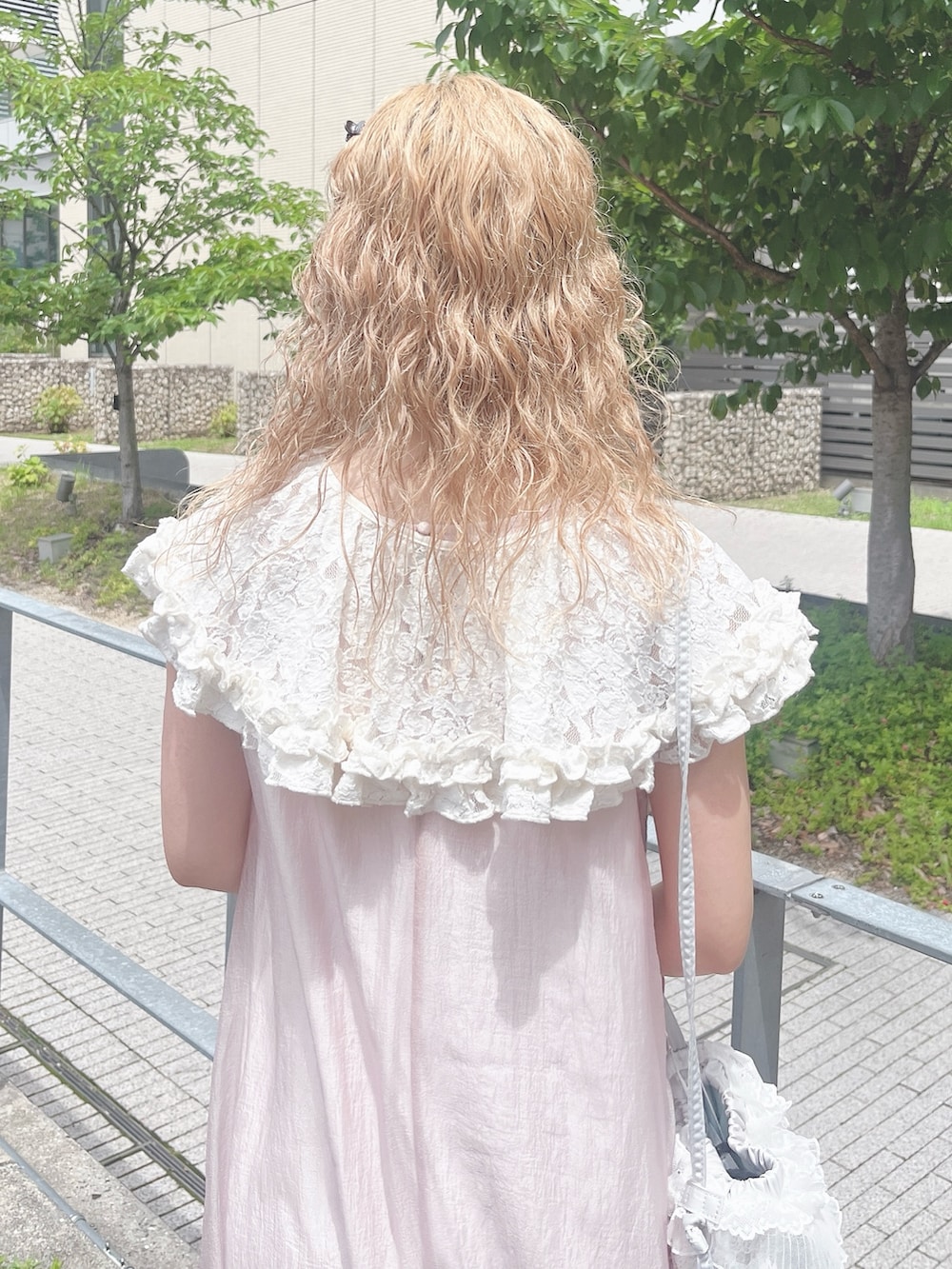 ピンク系のワンピース、ホワイト系のバレエシューズ、ブルー系のショルダーバッグを着用したレディースの夏コーディネートの7枚目の写真