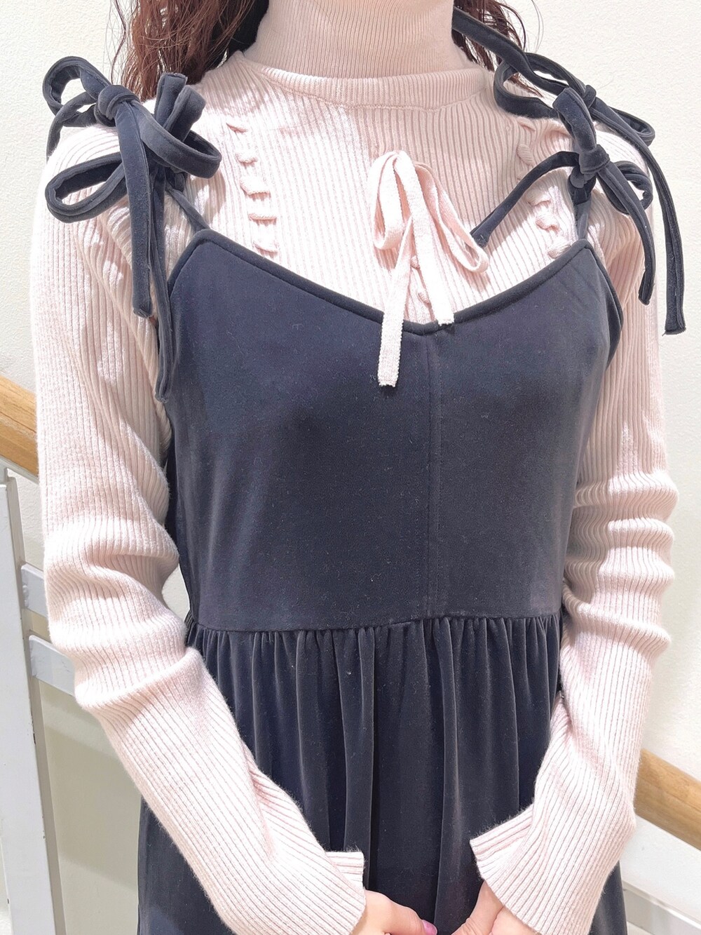 ピンク系のニット/セーター、グレー系のワンピース、ホワイト系のパンプスを着用したレディースの冬コーディネートの8枚目の写真