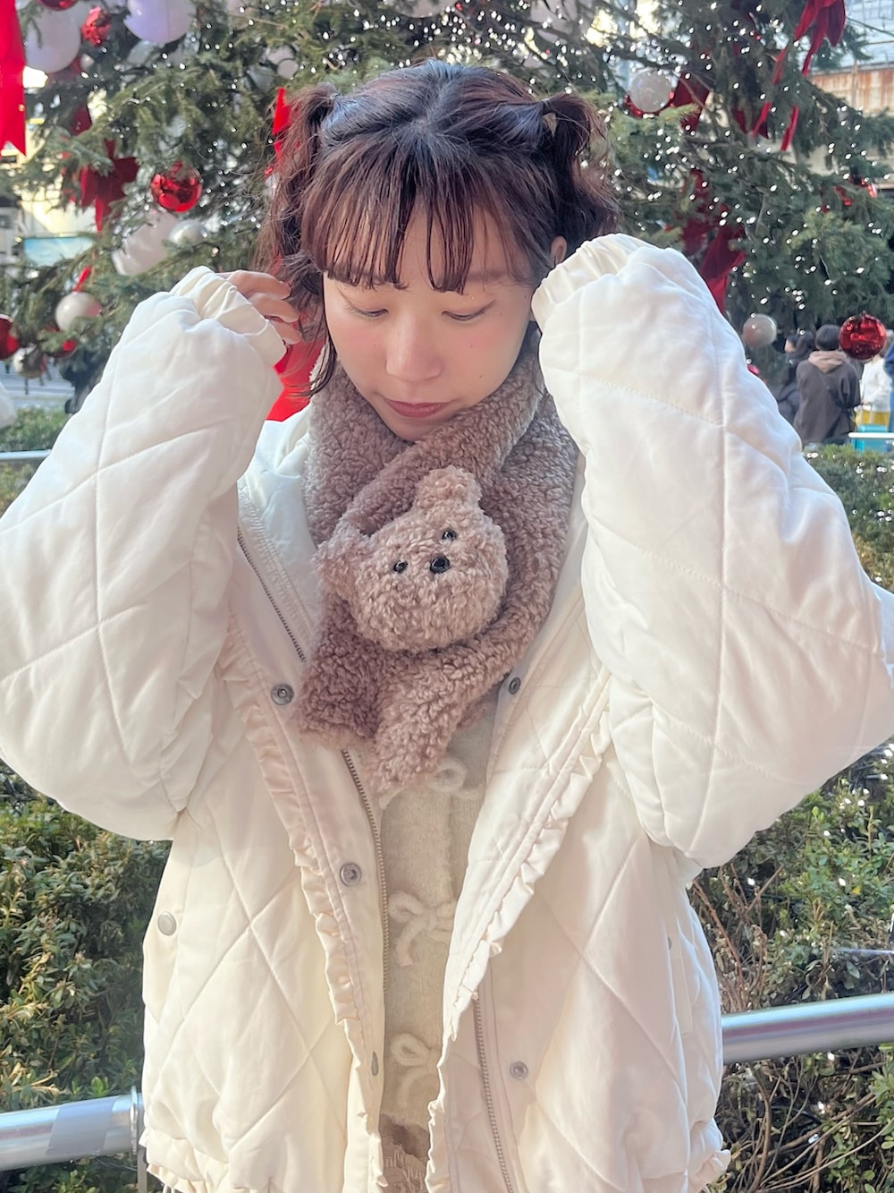 ホワイト系のカーディガン/ボレロ、ホワイト系のダウンジャケット/コート、ブラウン系のスカートを着用したレディースの冬コーディネートの3枚目の写真