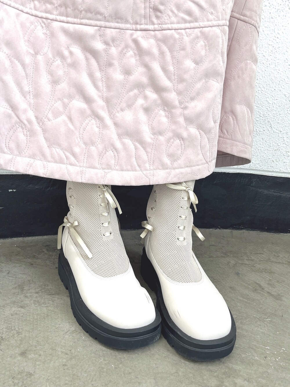 ホワイト系のニット/セーター、ピンク系のスカート、ホワイト系のブーツを着用したレディースの秋コーディネートの6枚目の写真