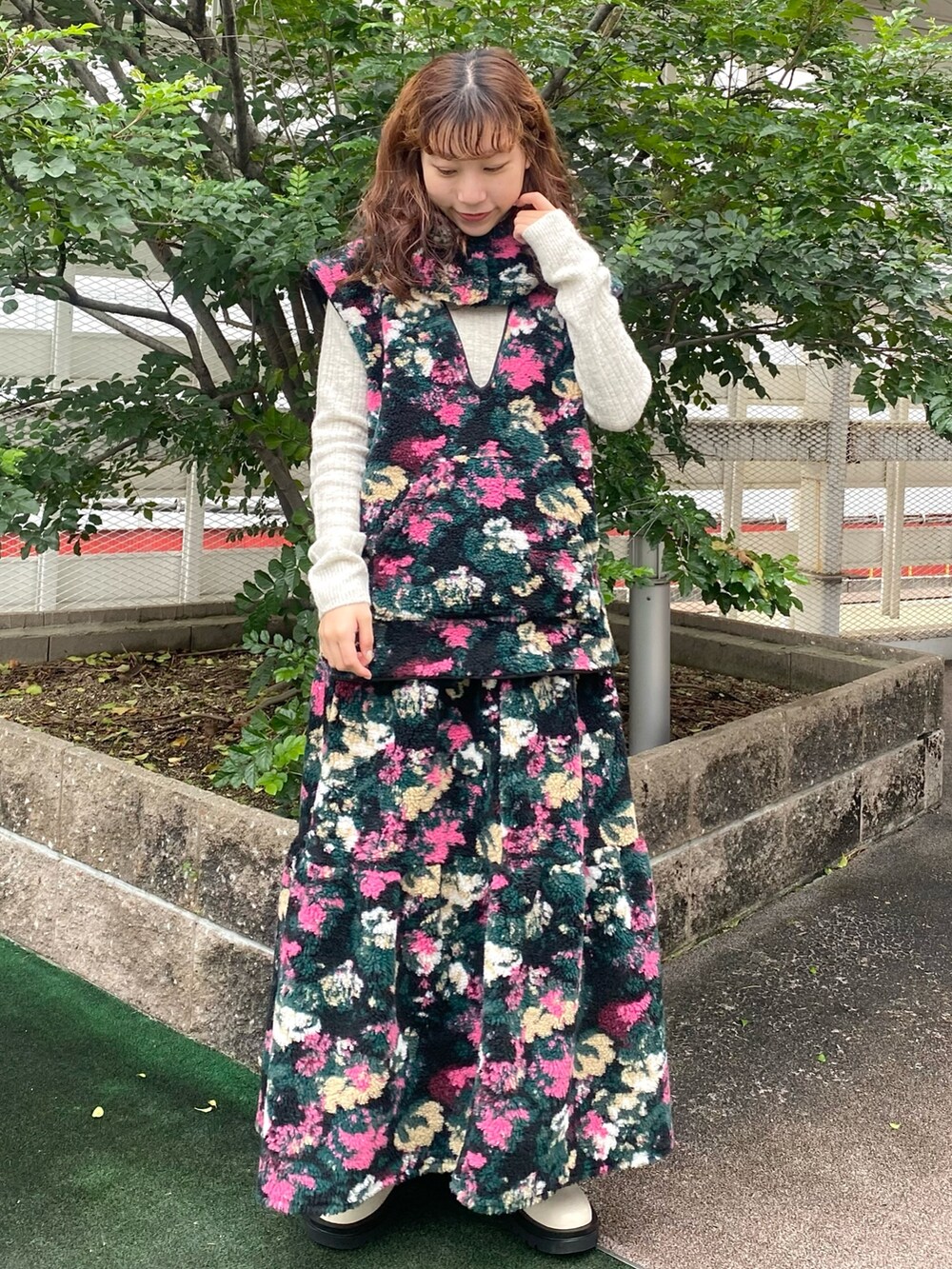 ブラック系のベスト、ブラック系のスカート、グレー系のニット/セーターを着用したレディースの秋コーディネートの2枚目の写真