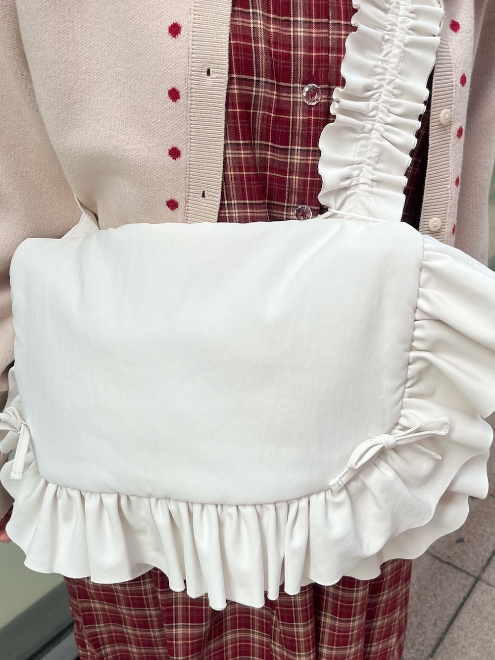 レッド系のワンピース、ホワイト系のカーディガン/ボレロ、ホワイト系のショルダーバッグを着用したレディースの秋コーディネートの9枚目の写真